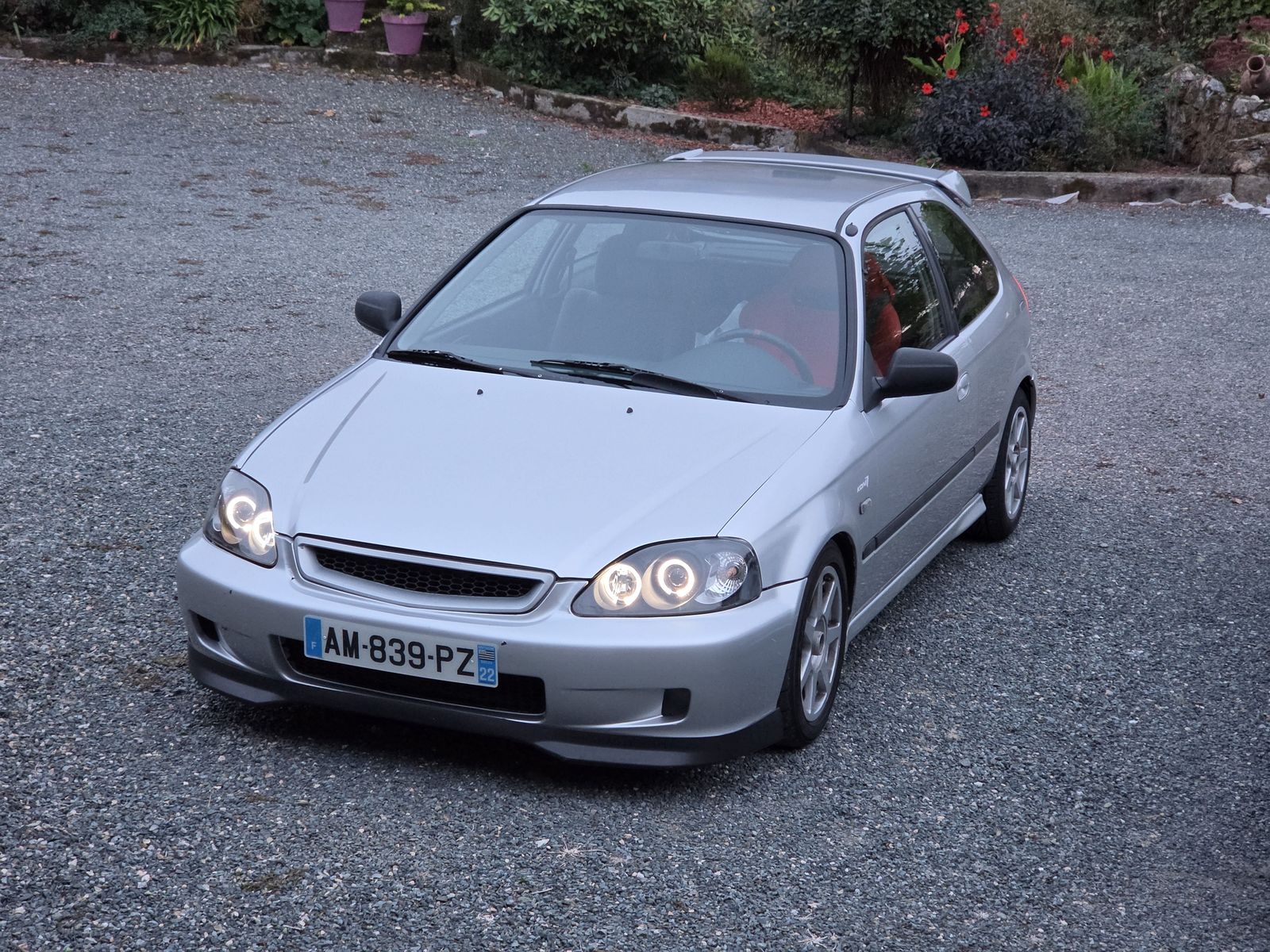 Honda Civic argent vue de trois quarts avant, phares angel eyes allumés